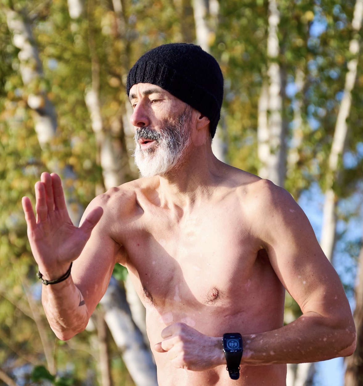 Kai Gröbner bei einer Körperübung im Freien vor herbstlichen Birken